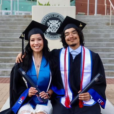 Lisa Martinez wears graduation regalia aside her son AJ Velazquez outside the University of Houston-Downtown's Marilyn Davies College of Business 