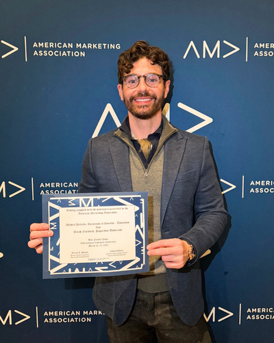 Michael Pettiette, Senior Lecturer at University of Houston-Downtown and Advisor for the the American Marketing Association at UHD, holds a certififcate at the american marketing association's international collegiate conference in March 2026.