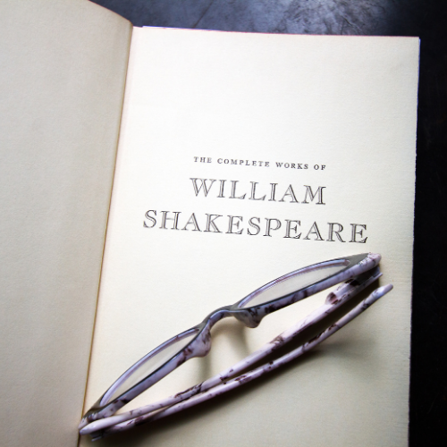 Eyeglass on an open book with text which reads 