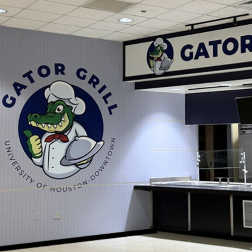 The Gator Grill at the University of Houston-Downtown's Food Court. A wall with a painting of an alligator in a chef outfit and text which reads Gator Grill, University of Houston-Downtown