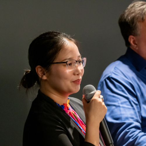 Dr. Hanjin Mao Assistant Professor Social Sciences at University of Houston-Downtown speaks into a microphone at the university's Nonprofit Management Night at 1801 Main