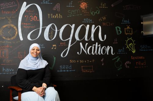 Rim Mohamed in front of a mural that says 