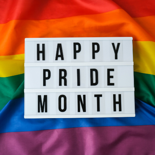 Rainbow flag and a sign which reads happy pride month